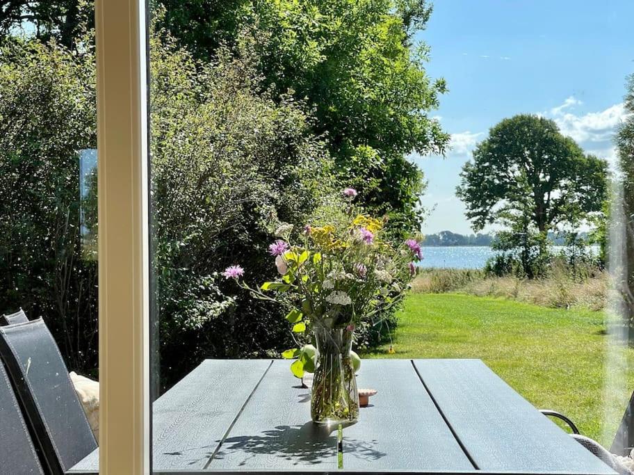 eine Blumenvase, die auf einem Tisch neben einem Fenster sitzt in der Unterkunft Pia´s Guesthouse in Askeby