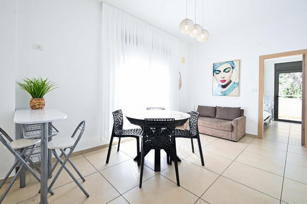 een eetkamer en een woonkamer met een tafel en stoelen bij Perfect Location 2BR in Reines by HolyGuest in Tel Aviv