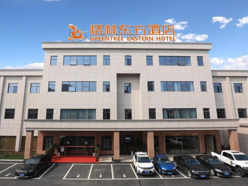 un edificio con auto parcheggiate in un parcheggio di GreenTree Eastern Hotel Anhui Xuancheng Guangde Old Cross Street a Guangde