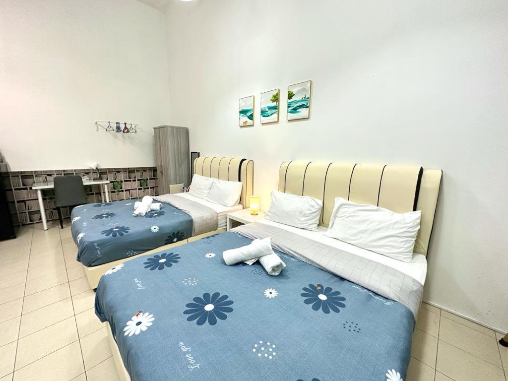 two beds in a room with blue and white sheets at CEO2 Soho Business Suite#Netfix#USM #PISA#Airport#Pantai Hospital in Bayan Lepas
