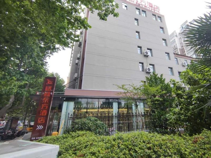 un edificio con una señal delante de él en GreenTree Eastern Hotel Huai'an Suning Plaza West Huaihai Road, en Huai'an