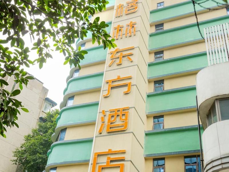 a building with orange writing on the side of it at GreenTree Eastern Hotel Chongqing Jiefangbei Children's Hospital in Chongqing