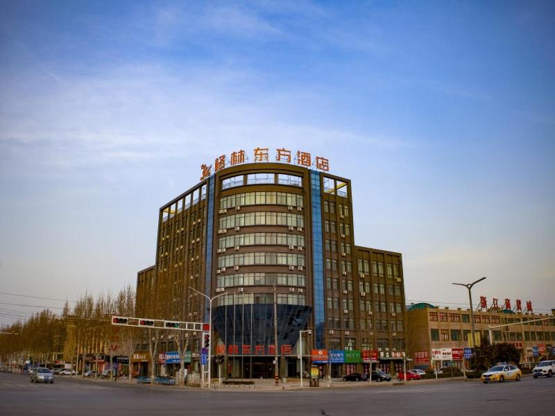 duży budynek z znakiem na górze w obiekcie GreenTree Eastern Hotel Hebi Jun County Passenger Station w mieście Xun