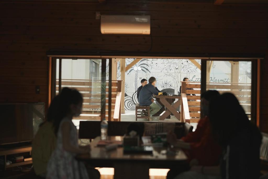 a group of people sitting at a table in a restaurant at Little Hermit - Vacation STAY 39645v in Tateyama