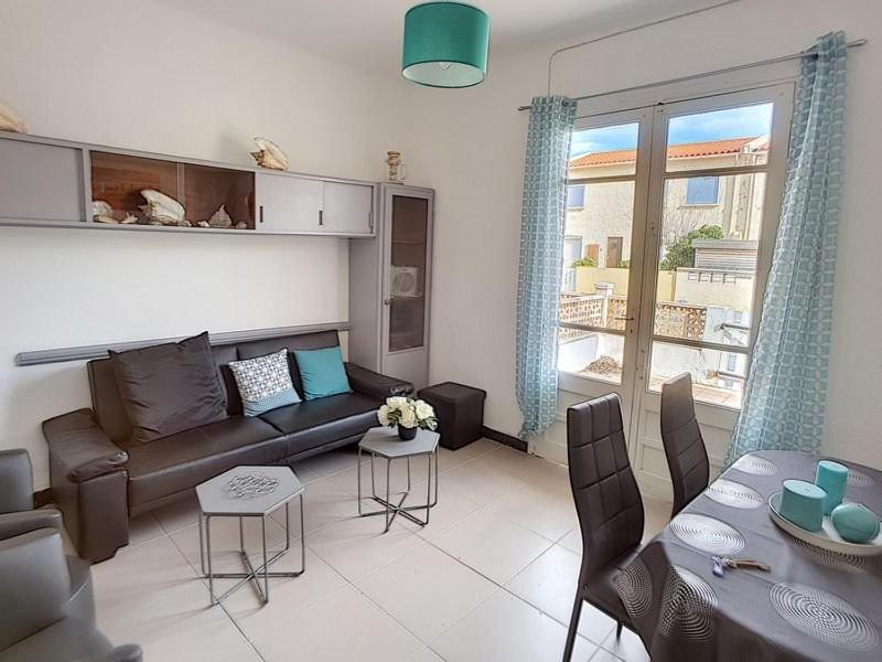 un salon avec un canapé et une table dans l'établissement Appartement avec accès direct à la plage, à Saint Pierre La Mer