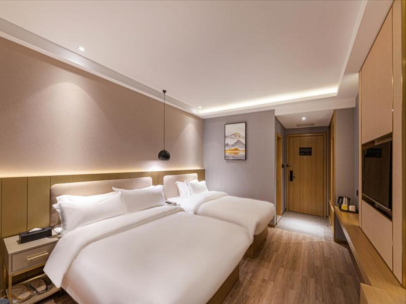 duże białe łóżko z białymi poduszkami w sypialni w obiekcie Gya Hotel Suzhou Hanshan Temple Binhe Road w mieście Suzhou