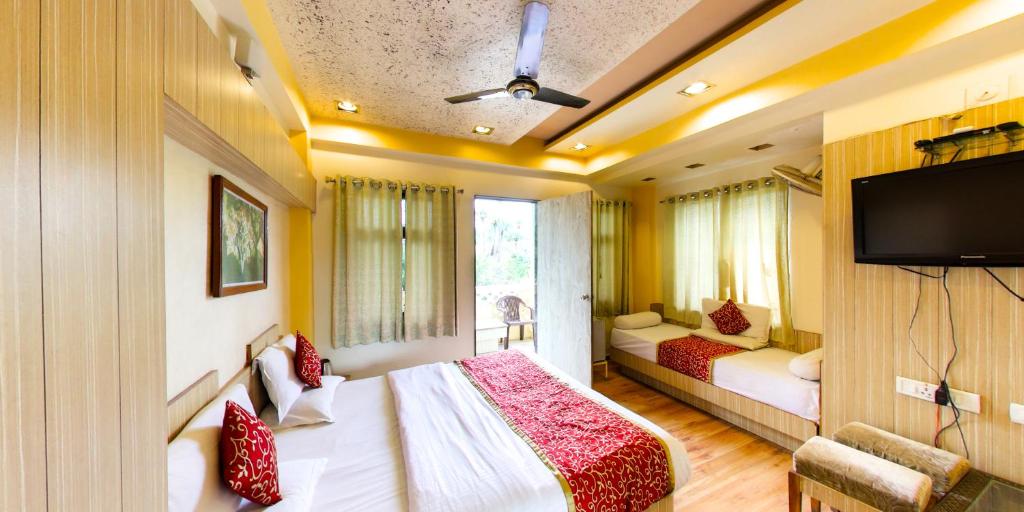 マウント・アブにあるHotel Vishramのベッドルーム1室(ベッド2台、薄型テレビ付)