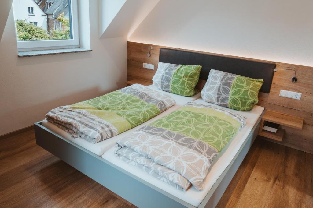een bed in een kamer met twee kussens erop bij Ferienweingut SerwaziWein in Mesenich