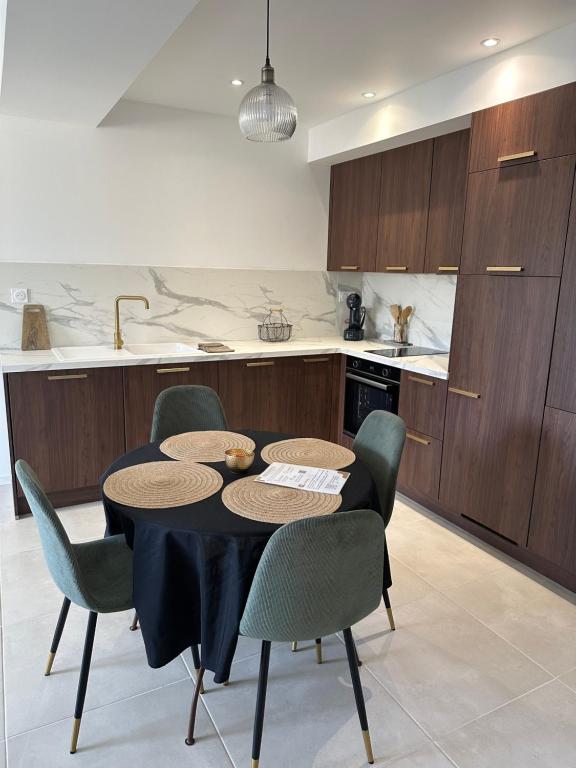 a kitchen with a table and chairs in a kitchen at Appartement neuf contemporain in Lourdes