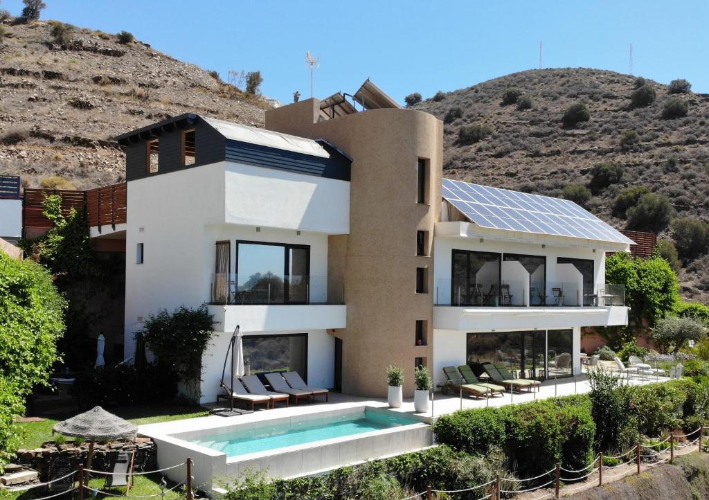 una casa con piscina di fronte a una montagna di Vive tu sueño a Torrox Costa