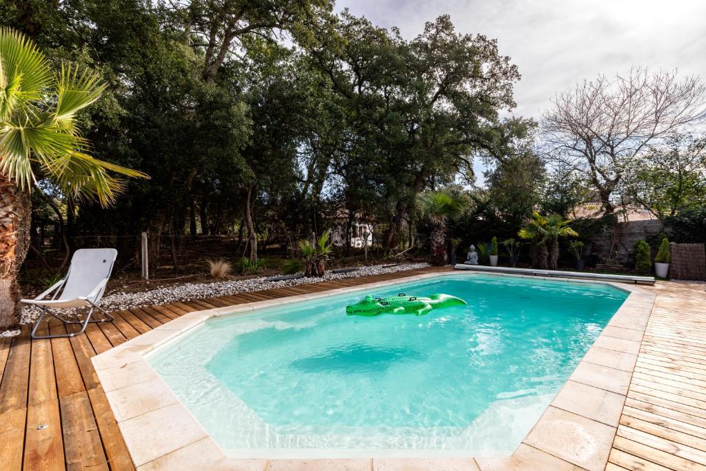 una piscina con un juguete verde en el agua en Landaise le lagunak avec piscine chauffée à 900 M de la plage, en Labenne