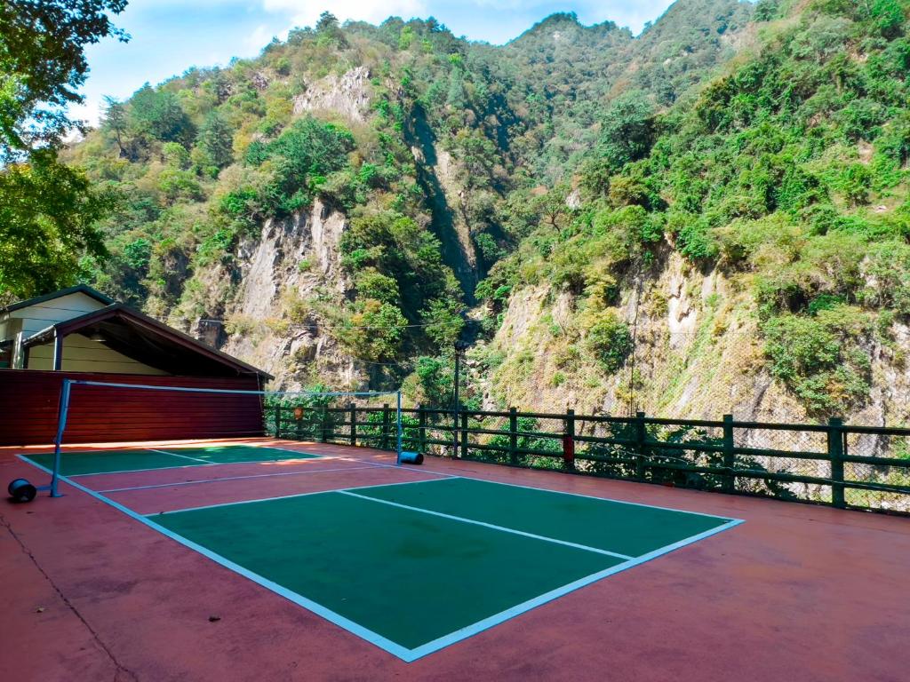 a tennis court with a mountain in the background at Uni-Resort Ku-Kuan in Heping