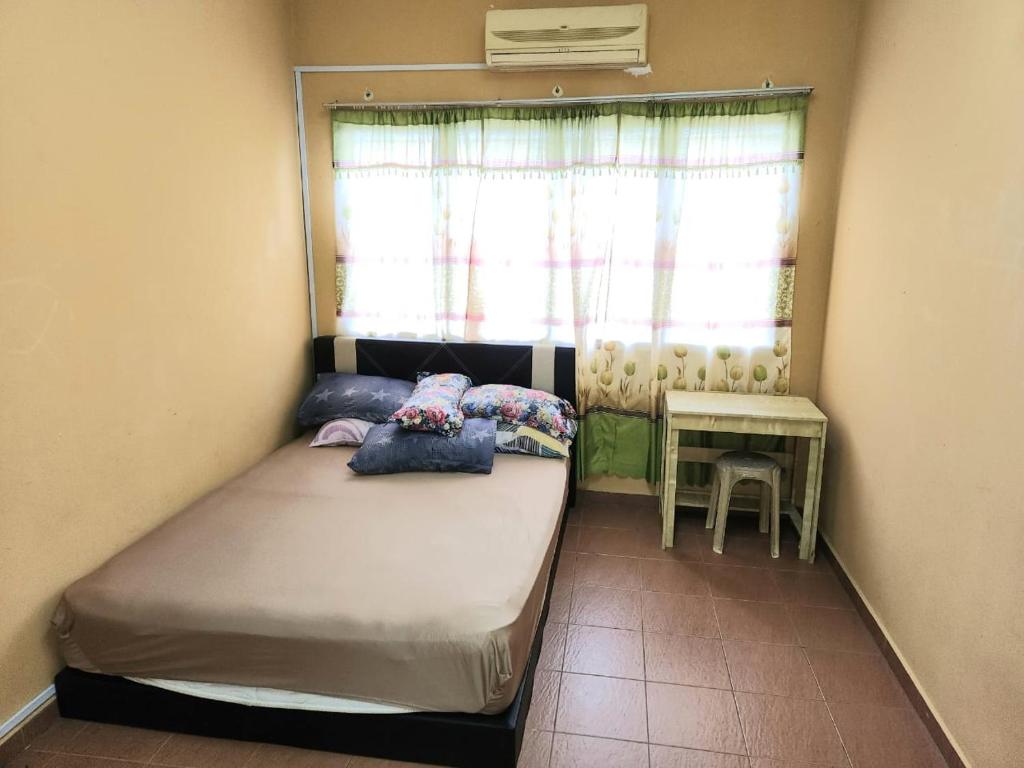 een kleine slaapkamer met een bed en een raam bij Reyza Homestay KKB in Kuala Kubu Baharu