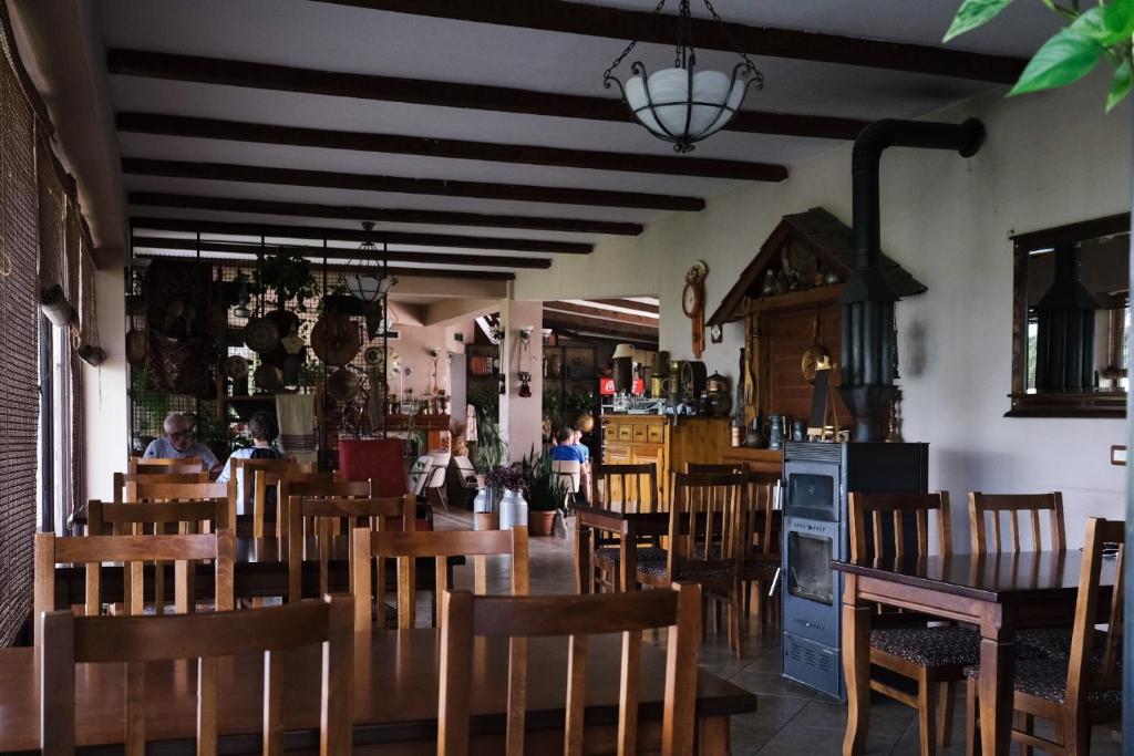 BurrelにあるHotel Vila Bruciの木製のテーブルと椅子、人々を背景に設置したレストラン