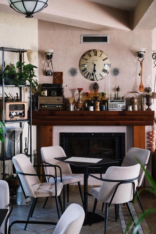 a dining room with a table and chairs and a clock at Hotel Vila Bruci in Burrel