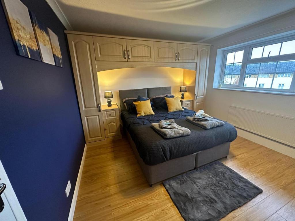 ein Schlafzimmer mit einem Bett und einem großen Fenster in der Unterkunft Stylish townhouse-Sleeps 9-Free parking in Milton Keynes