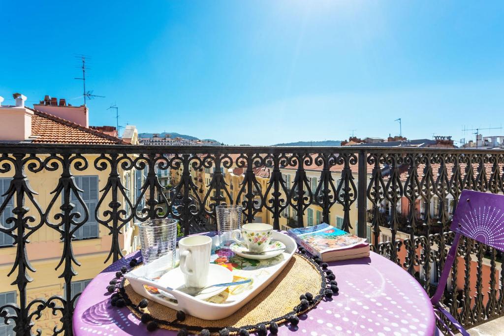 una mesa con una bandeja de comida en el balcón en ICONIC 2 AP4375 By Riviera Holiday Homes, en Niza