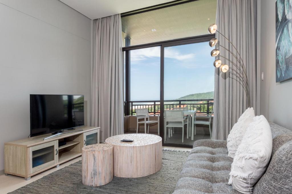 a living room with a couch and a television at 602 Zimbali Suites, Ocean View in Ballito