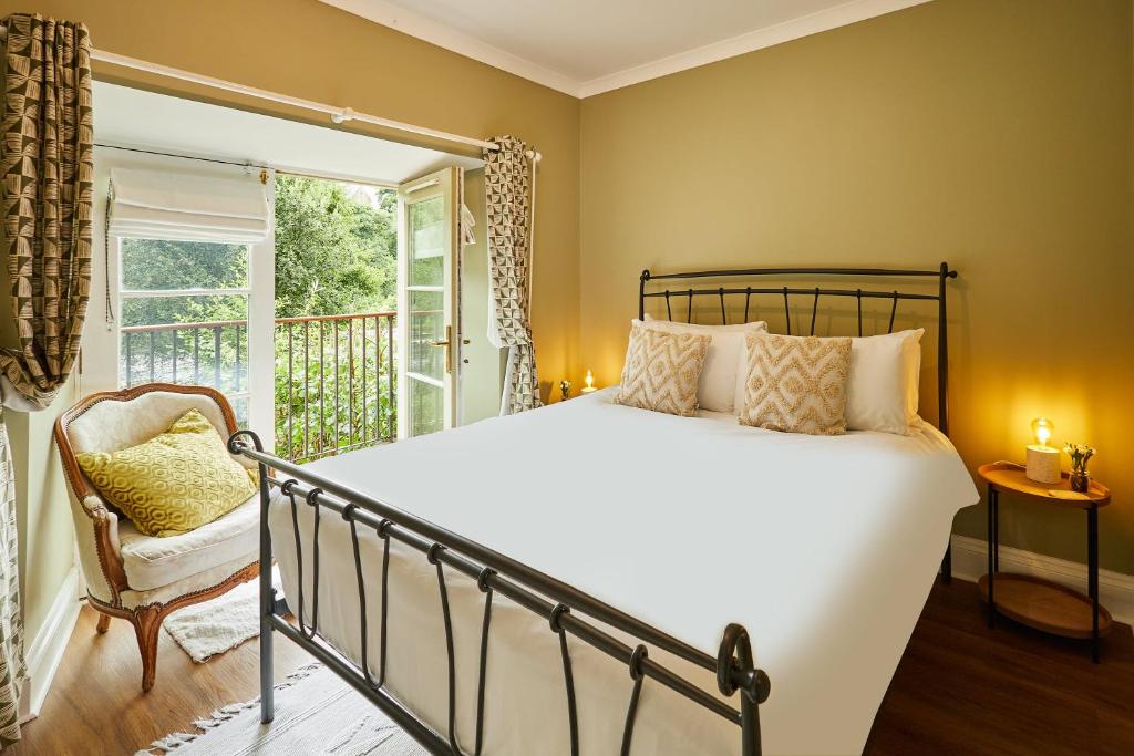 een slaapkamer met een bed, een raam en een stoel bij Host & Stay - River View Cottage in Barnard Castle