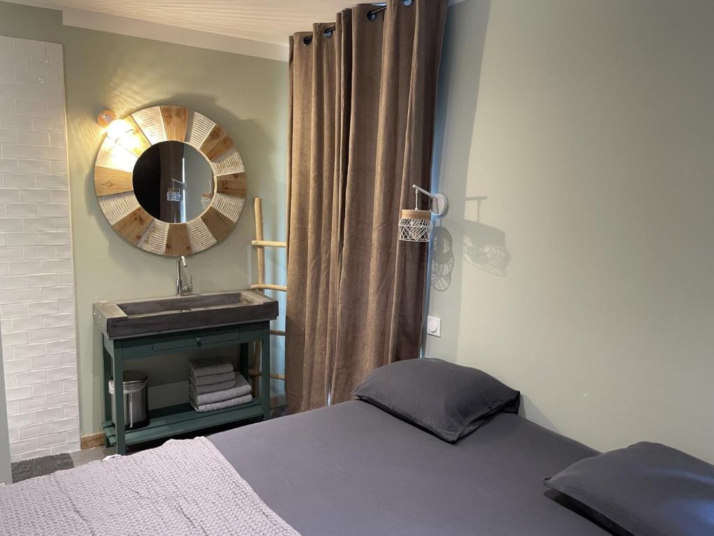 - une chambre avec un lit, un miroir et un lavabo dans l'établissement Côté Nuit, à Capestang