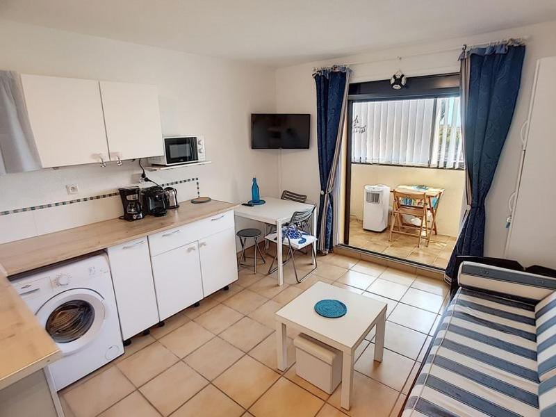 une cuisine avec une machine à laver et une table dans l'établissement Jolie studio, à Saint Pierre La Mer