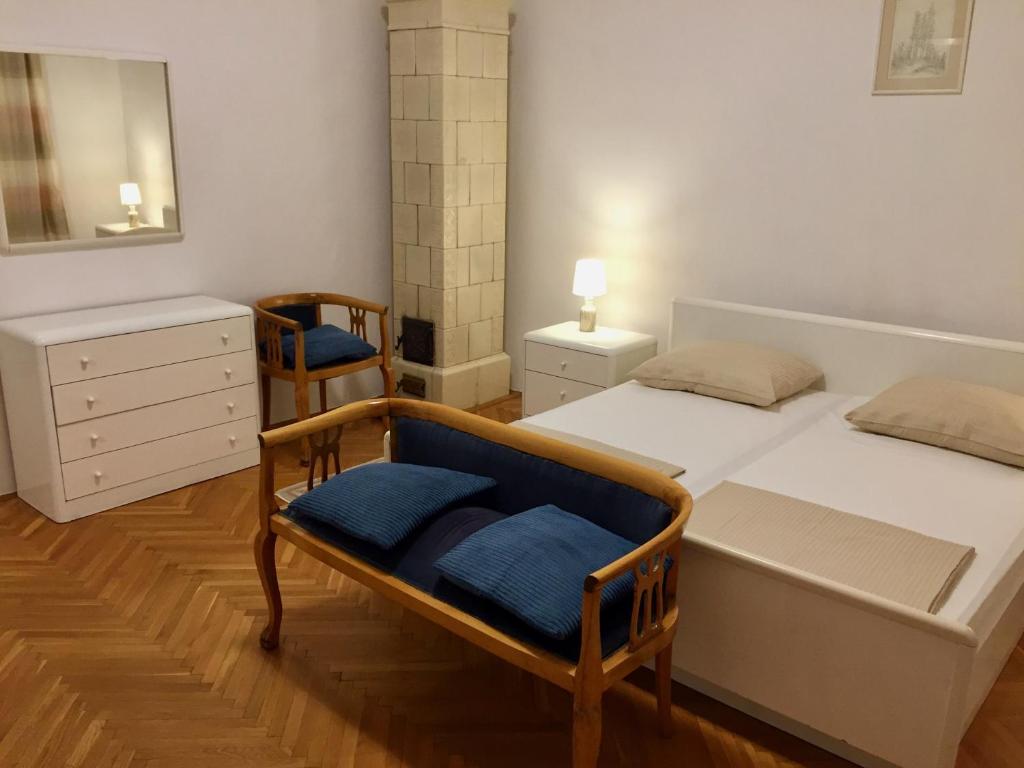 een slaapkamer met een bed, een stoel en een spiegel bij Guest House Gaj Sarajevo in Sarajevo