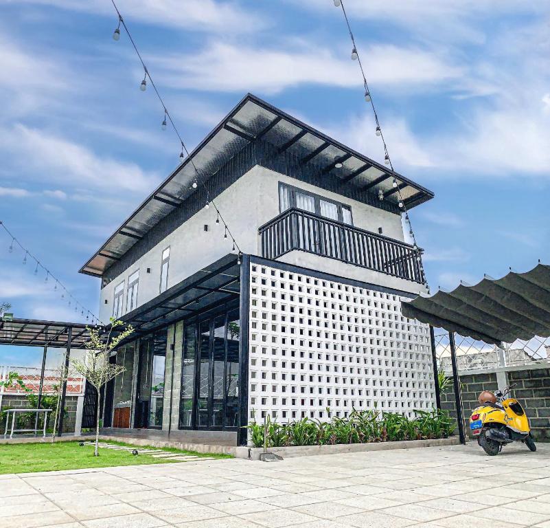 un bâtiment avec un scooter garé devant lui dans l'établissement C House Villa Venuestay, à Vung Tau