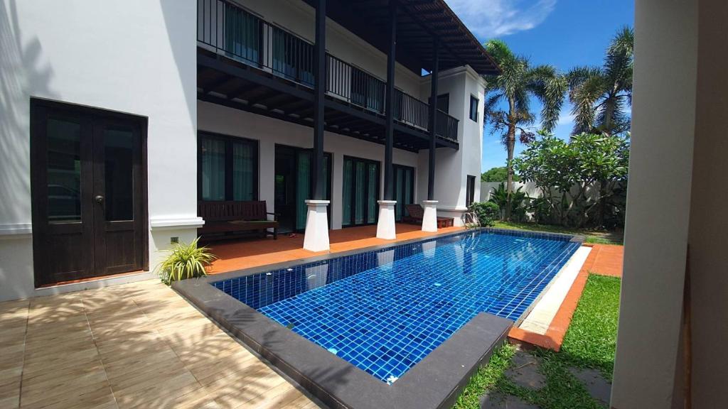 a swimming pool in front of a house at Blu Village Pool Villa in Bang Tao Beach