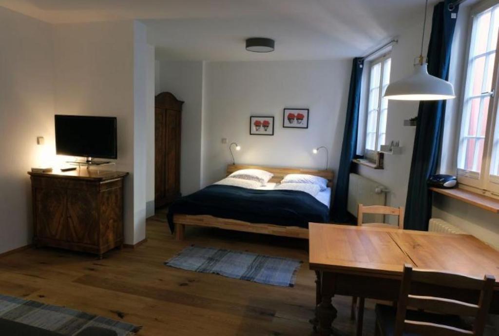 1 dormitorio con cama, mesa y TV en Ferienwohnung Scheffelhaus en Gengenbach