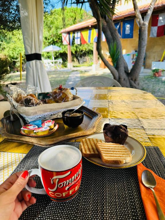 un tavolo con un piatto di cibo e una tazza di caffè di EL MATORRAL ad Alghero