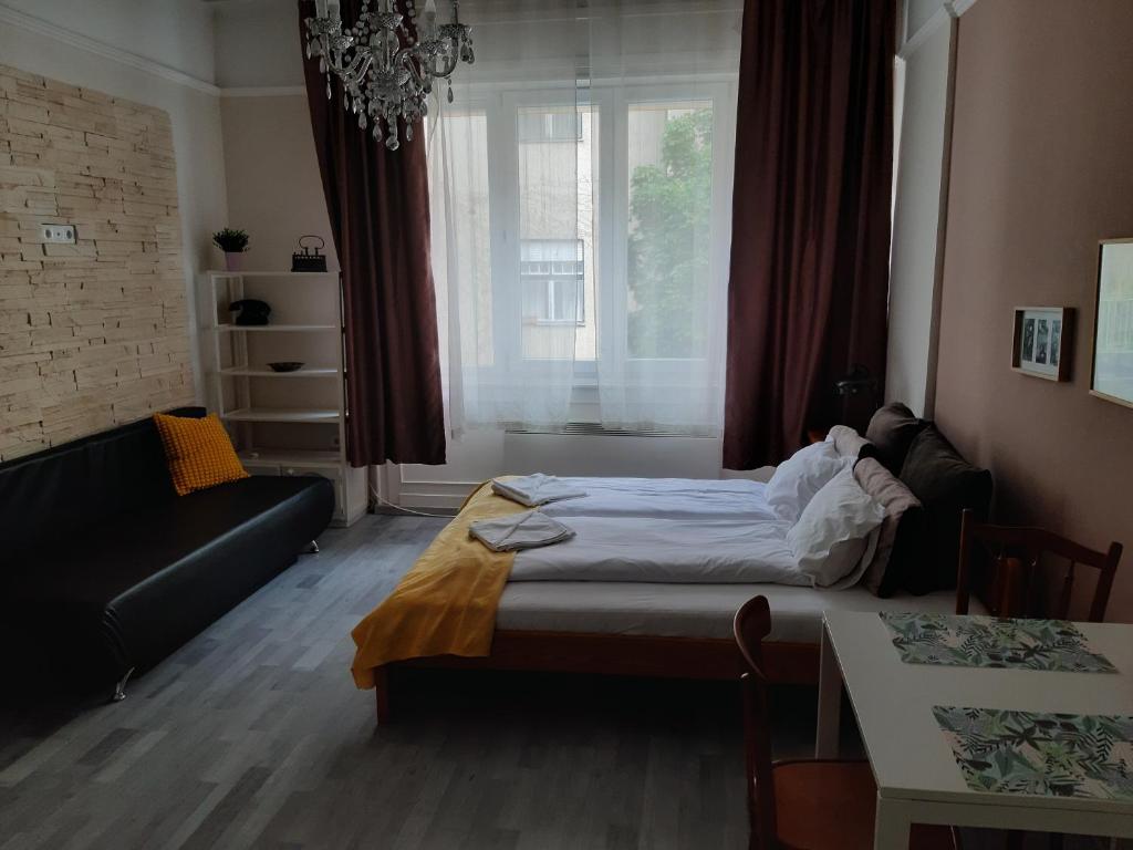 ブダペストにあるBpR Deco Relic Studioのベッドルーム1室(ベッド1台、ソファ、窓付)