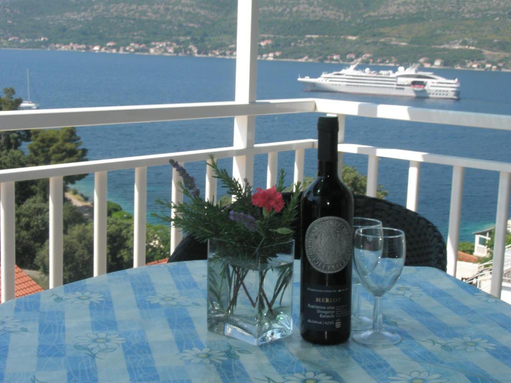 una botella de vino sentada en una mesa con una copa en Apartments Baric, en Korčula