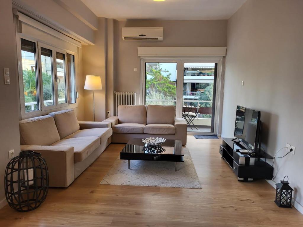 een woonkamer met een bank en een salontafel bij Spacious Apartment In N. Smirni in Athene