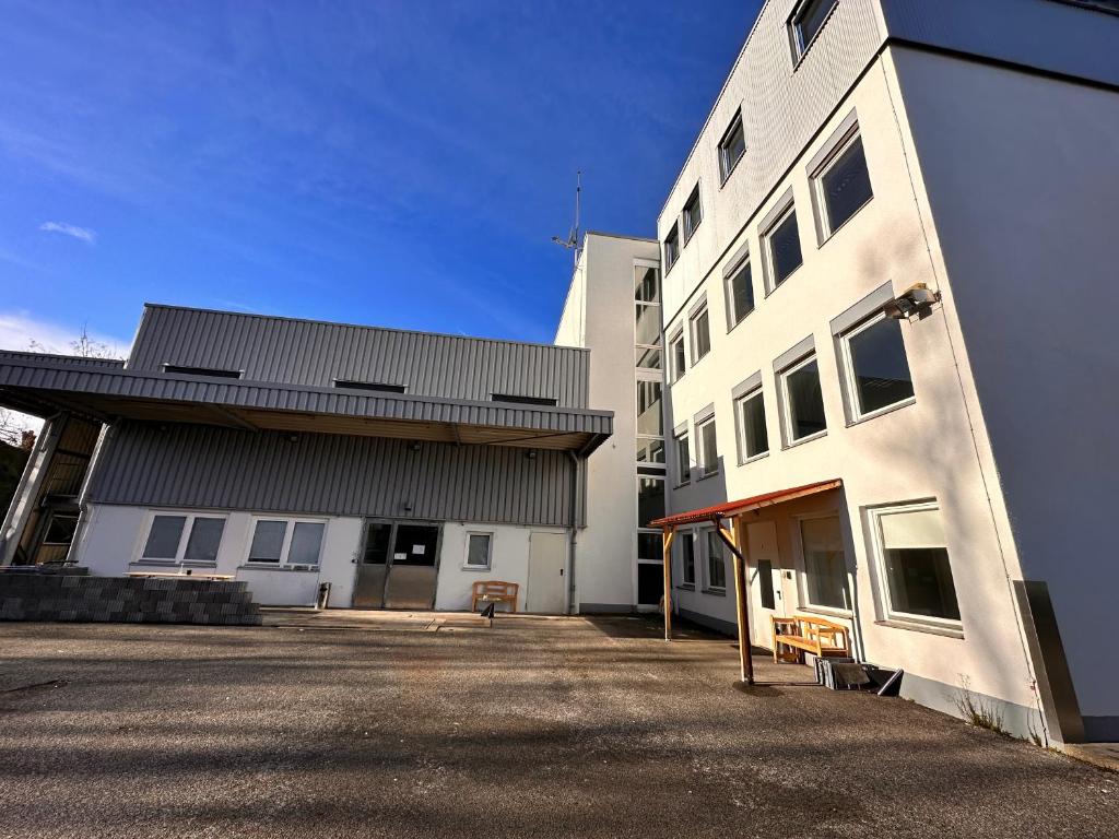 a large white building next to a white building at Monteurunterkunft Schwaig in Schwaig bei Nürnberg