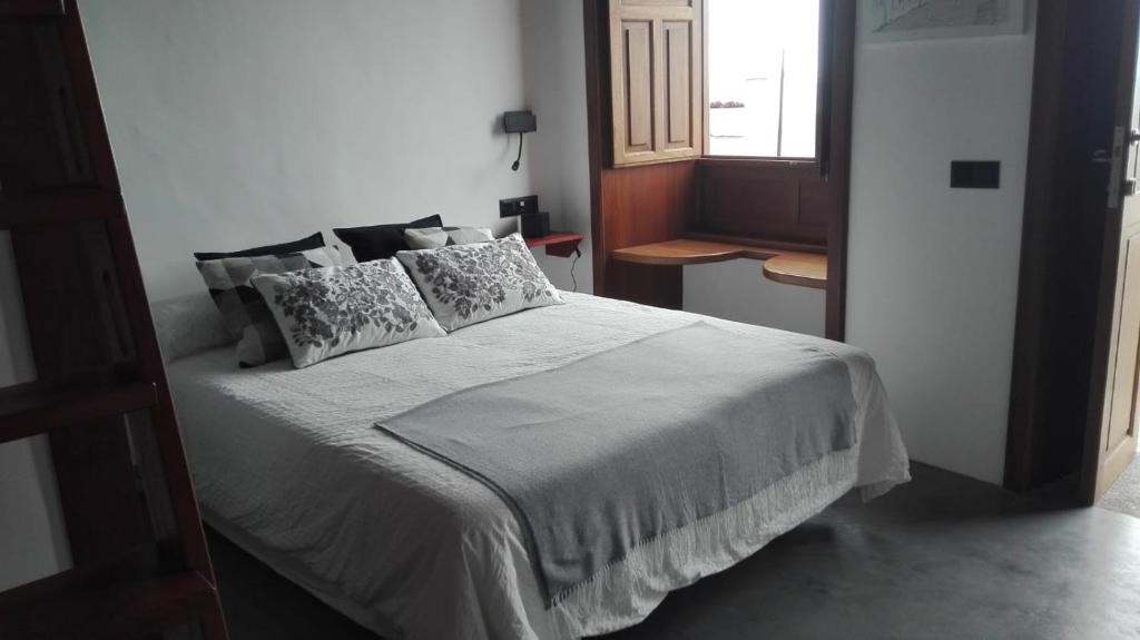 Un dormitorio con una cama blanca con almohadas y una ventana en Vivienda Vacacional San Roque, 30 en Garachico