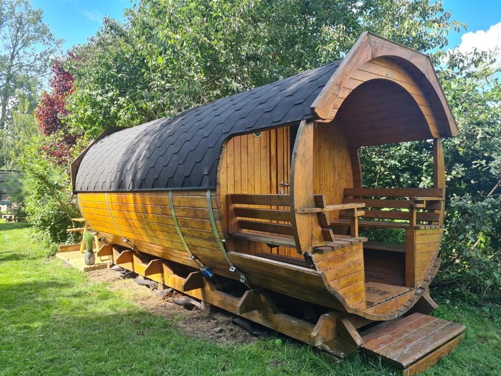 ein kleines Holzboot auf dem Rasen in der Unterkunft Le Tonneau insolite du Souffle du Saule in Buhl-Lorraine