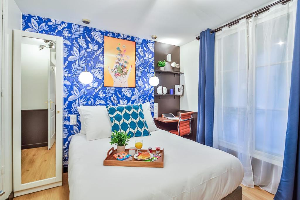 Un dormitorio con una cama con una bandeja de comida. en Apartments WS Louvre - Saint-Germain, en París