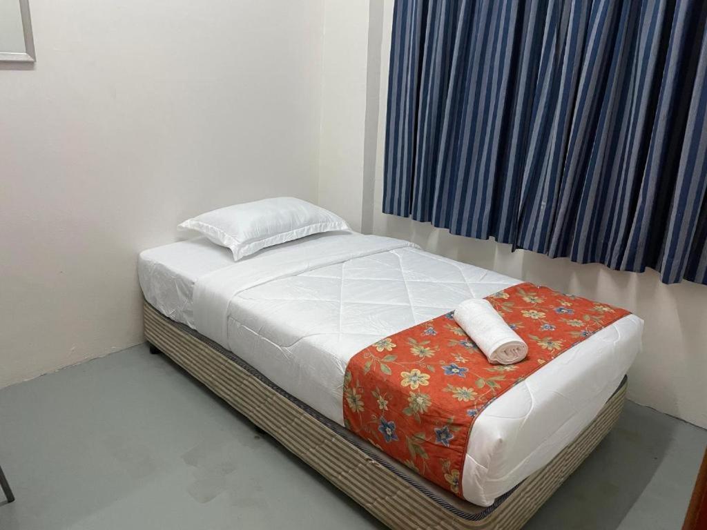 uma pequena cama num quarto com uma janela em Wau Sayang Sayang Guest House em Malaca