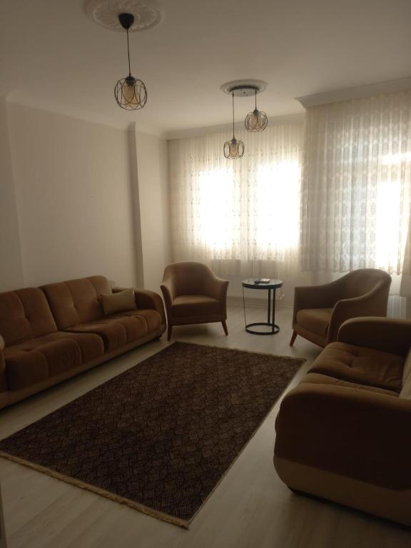 ein Wohnzimmer mit einem Sofa, Stühlen und einem Tisch in der Unterkunft PEKER Apart in Pelitli