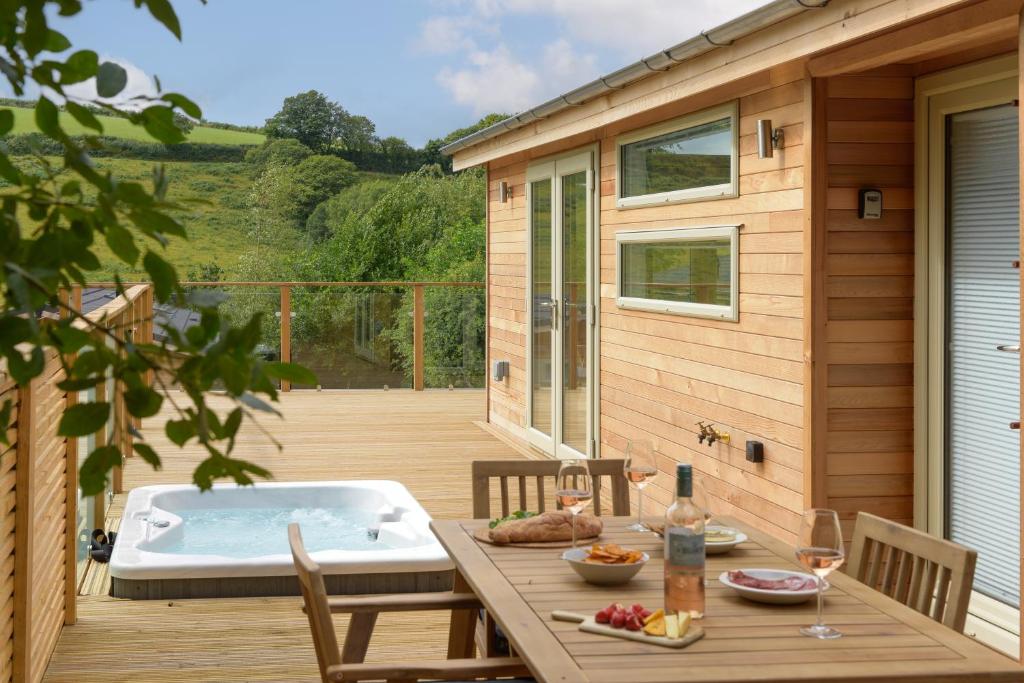 a deck with a hot tub and a table and chairs at 4 Valley View in Looe