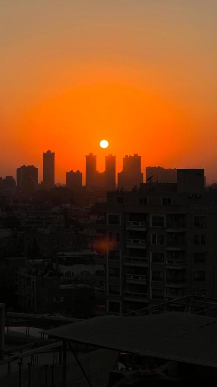 - un coucher de soleil sur une ville dans l'établissement Room, au Caire