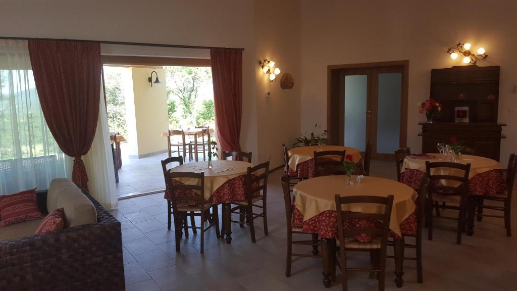 a dining room with tables and chairs and a living room at Agriturismo Gradec in Aurisina