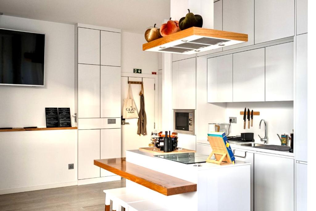 cocina con armarios blancos y encimera en Cristalia,Roof terrace in city center, Garage, Netflix 75inch TV, en Funchal