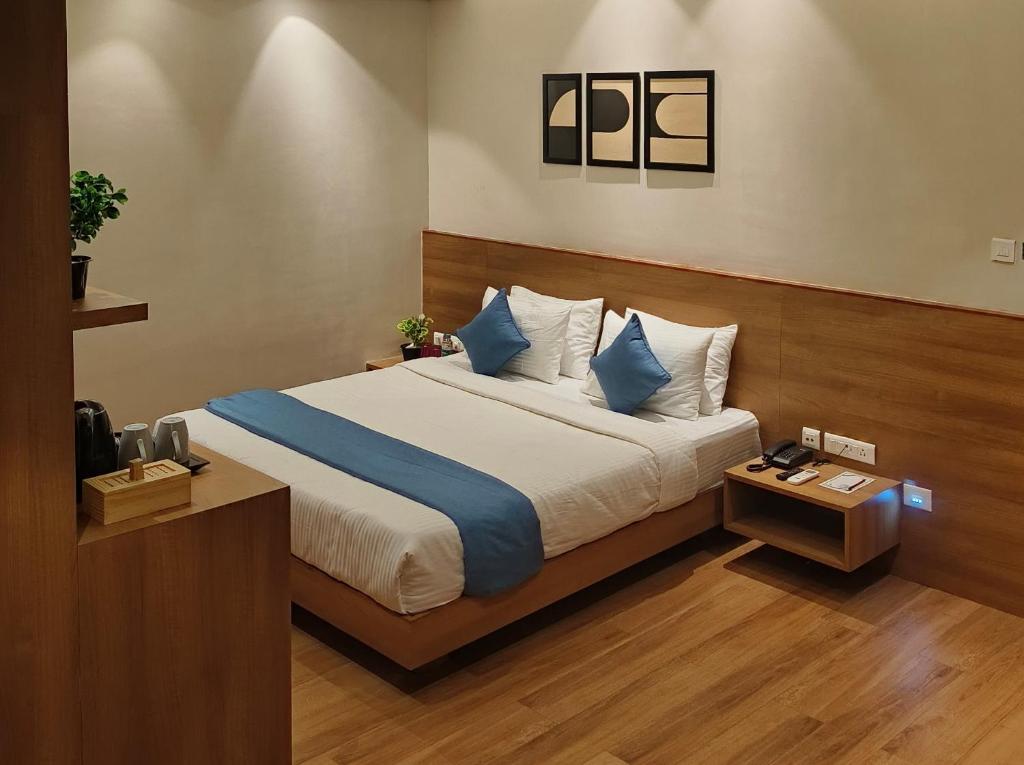 um quarto com uma cama com almofadas azuis e brancas em CENTRAL INN em Dibrugarh