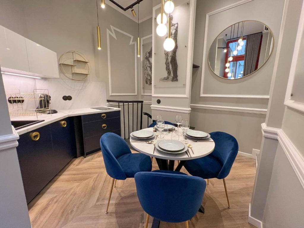 巴黎的住宿－Palais Royal - Chez Lucas，一间带桌子和蓝色椅子的用餐室