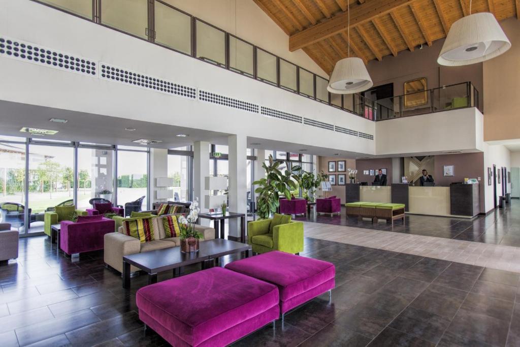 a lobby with purple and green furniture at Hotel & Residence Villa Bartolomea in Villa Bartolomea