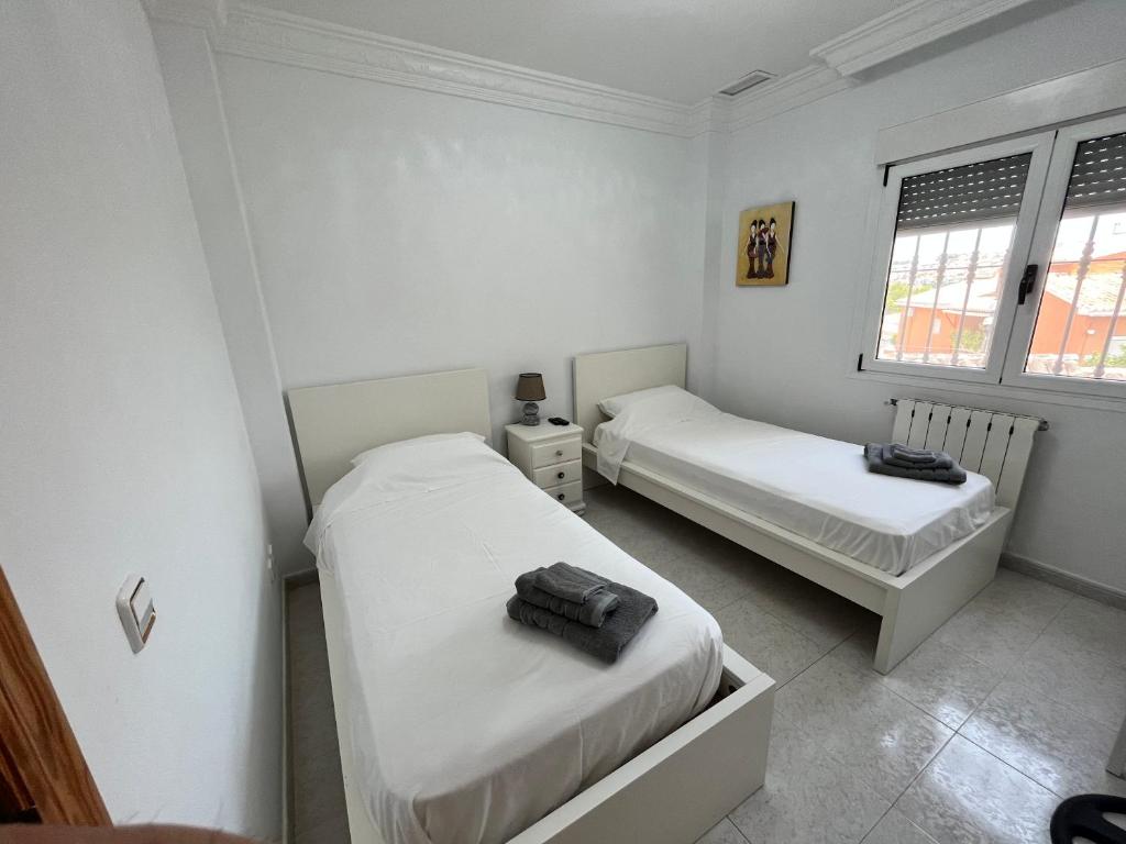 2 letti in una camera con pareti e finestre bianche di Casa Rose - 4-Bed villa with private pool in Calpe a Calpe