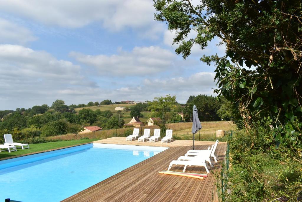una piscina con tumbonas blancas y una piscina en Les Granges en Marquay