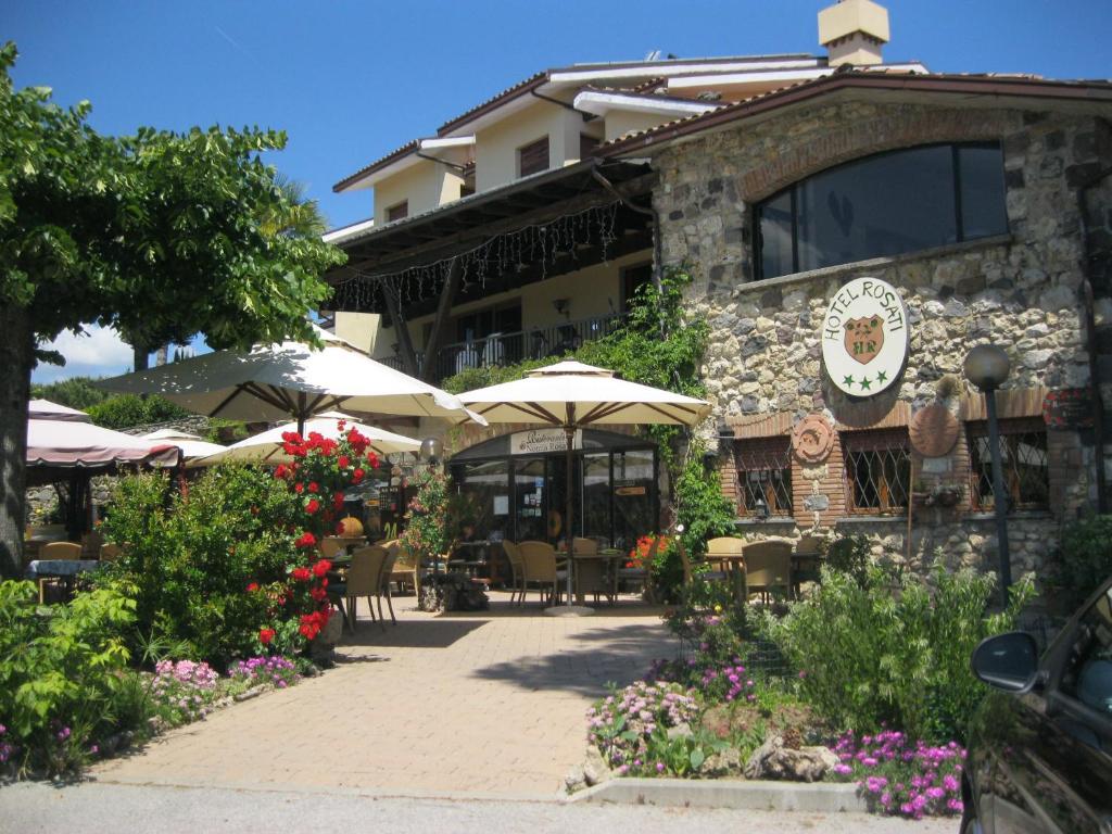 an outdoor cafe with umbrellas and tables at Hotel Rosati in Chiusi
