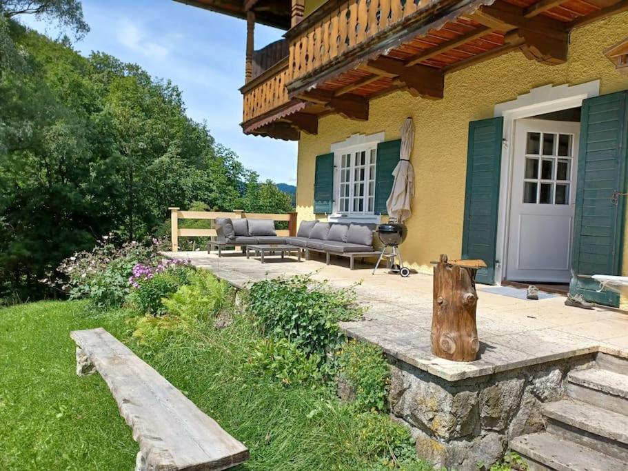 un porche de una casa con un banco y una casa en Ferienwohnung 'Bergidylle' - Zu Fuß auf die Loipe und den Berg, nur wenige Minuten ins Skigebiet, en Bayrischzell